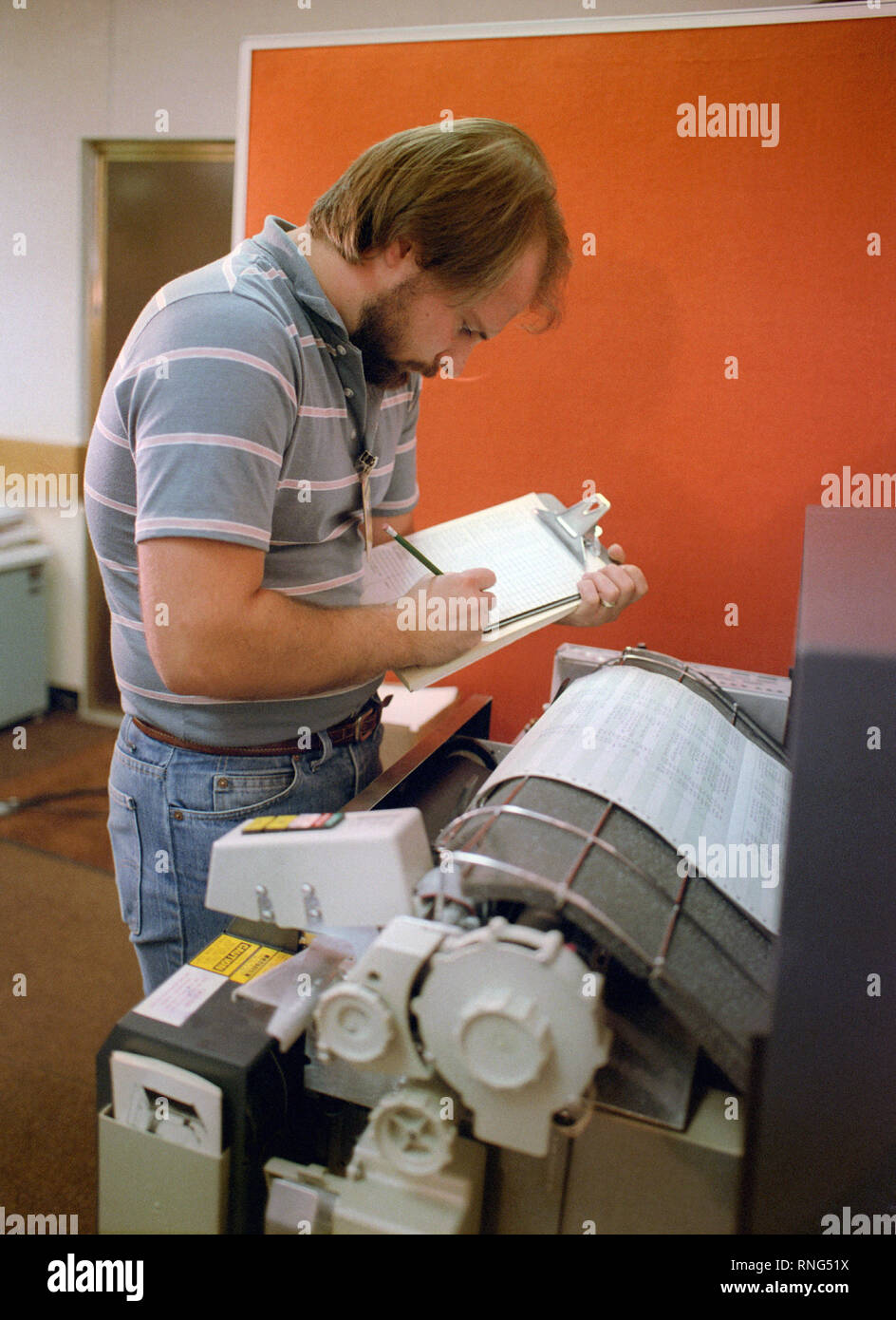 A technician monitors a computer printout while testing the electrical circuits of an MGM-118 Peacekeeper (formerly MX) intercontinental ballistic missile control guidance system. Stock Photo