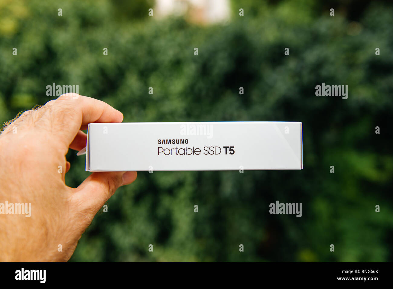 PARIS, FRANCE - AUG 14, 2018: Man hand holding side box Samsung T5 Portable  SSD 2 tb external hard drive disk with high read and write speed against  green background unboxing testing Stock Photo - Alamy