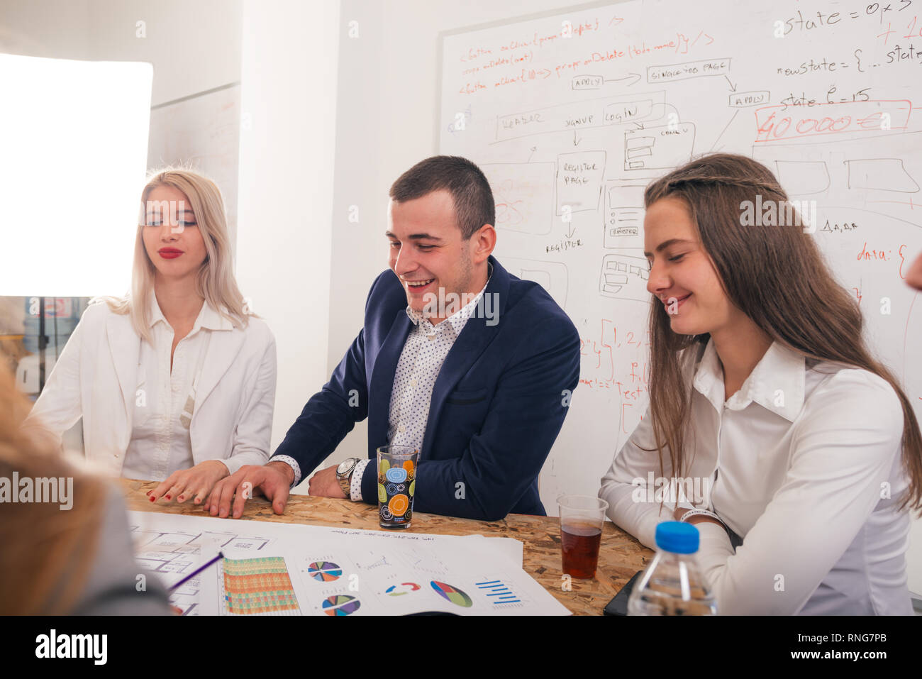 Handsome businessman with his two female architects smiling and discussing a project. Stock Photo