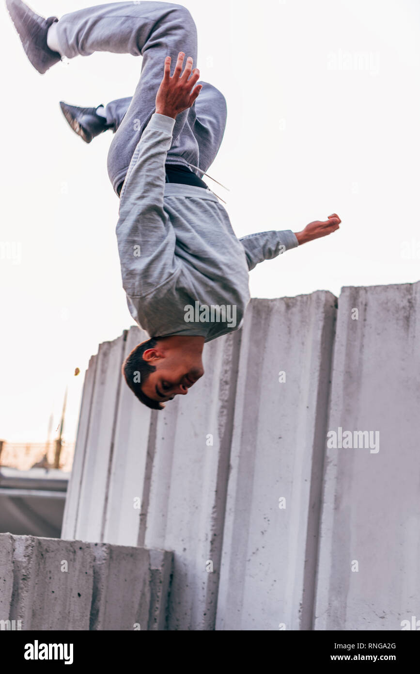 Acrobat man training parkour exercise while jumping backflip obstacles ...