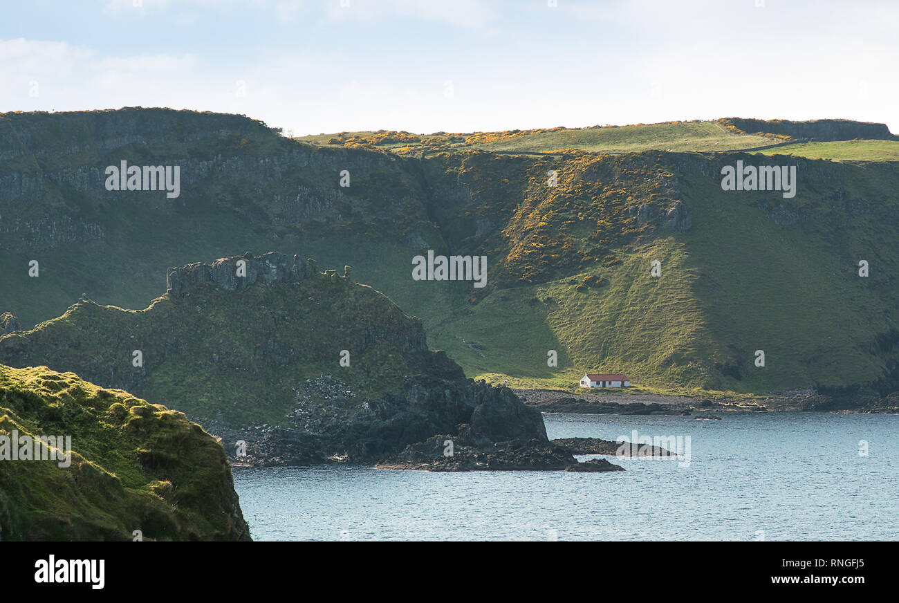 A view along the Antrim coastline of Northern Ireland, between Dunseverick Castle and Giant's Causeway, with a remote barn in the distance. Stock Photo