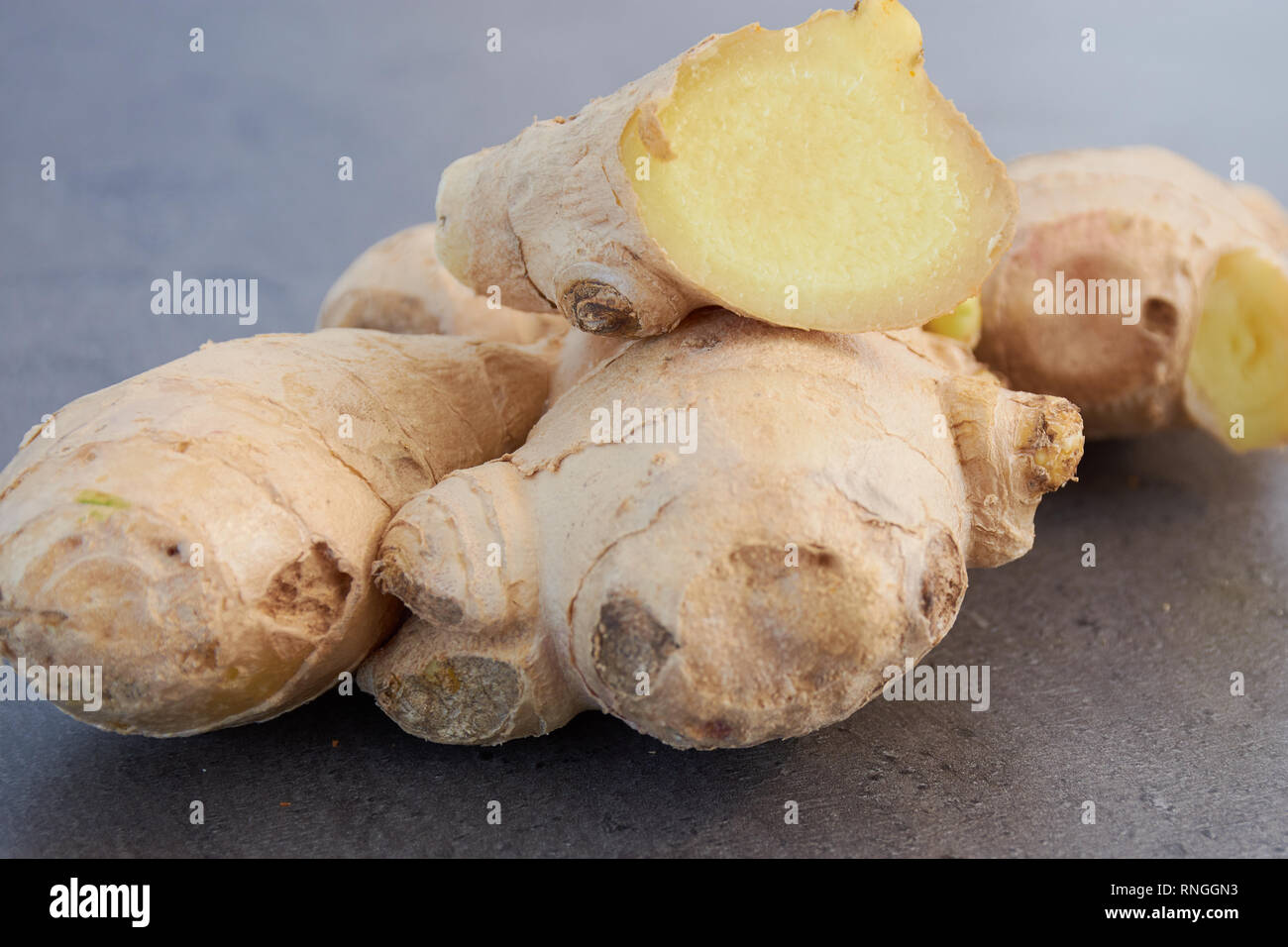 sliced fresh ginger on a grey kitchen surface Stock Photo