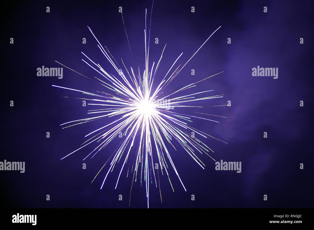 Bright white fireworks exploding in the night sky Stock Photo