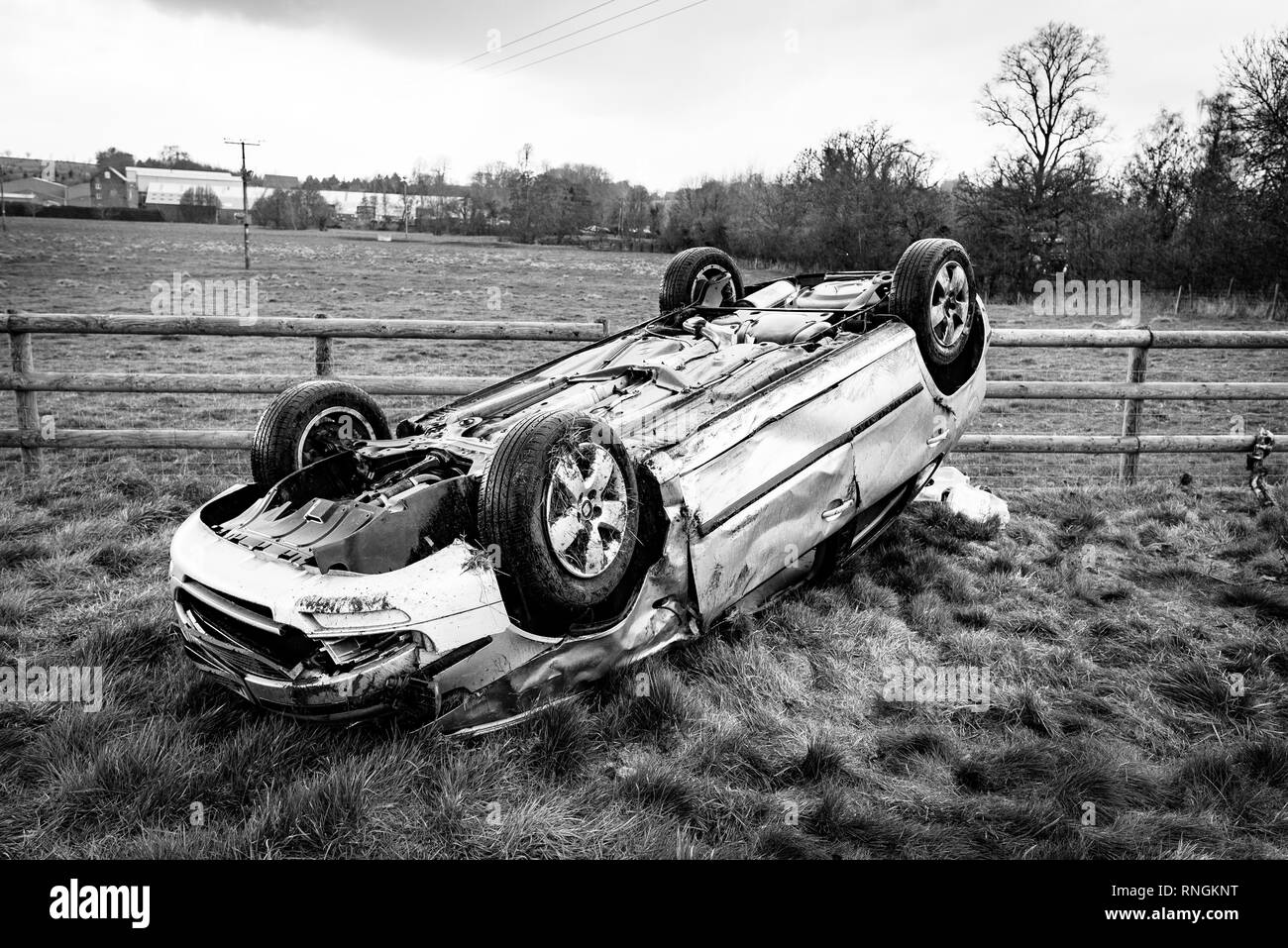 Car Crash and Car Damage. Vehicle upside down in a field surrounded by broken glass and debris after a high speed crash. Stock Photo