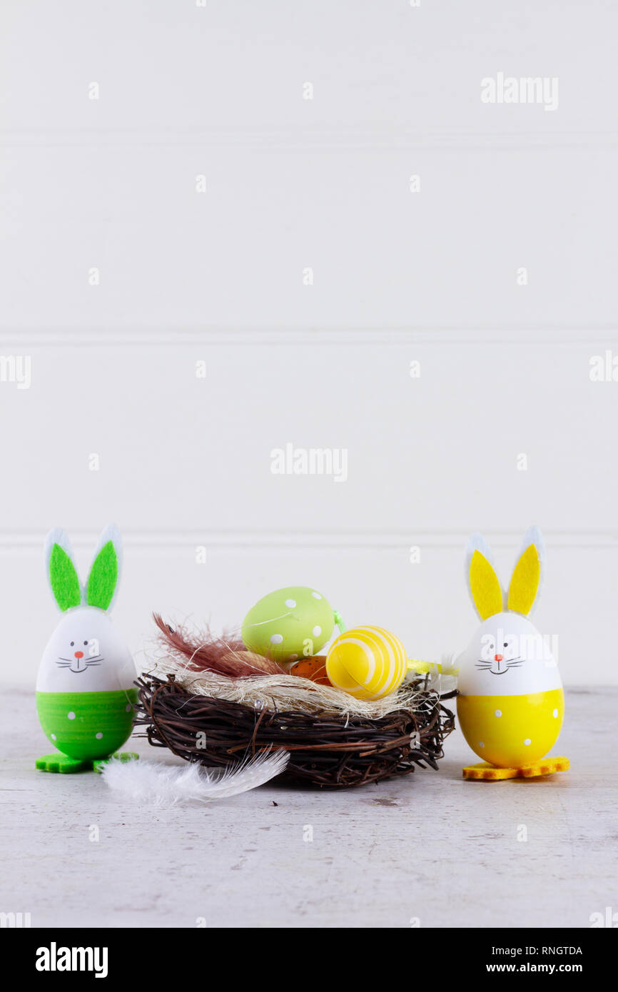 Easter scene with colored eggs in nest and green rabbit, copy space ...