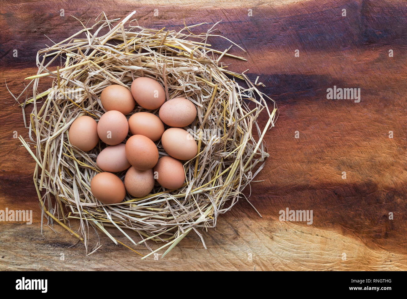 Top view of Chicken, Easter eggs in nest on a wooden table background ...