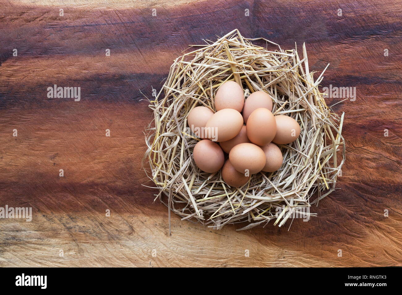 Top view of Chicken, Easter eggs in nest on a wooden table background ...