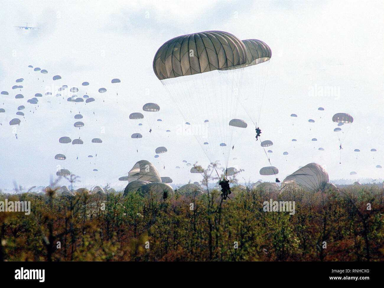 Paratroopers descend at Drop Zone B-70 during Dragon Team, the largest non-Joint Chiefs of Staff airdrop training exercise in history. Stock Photo