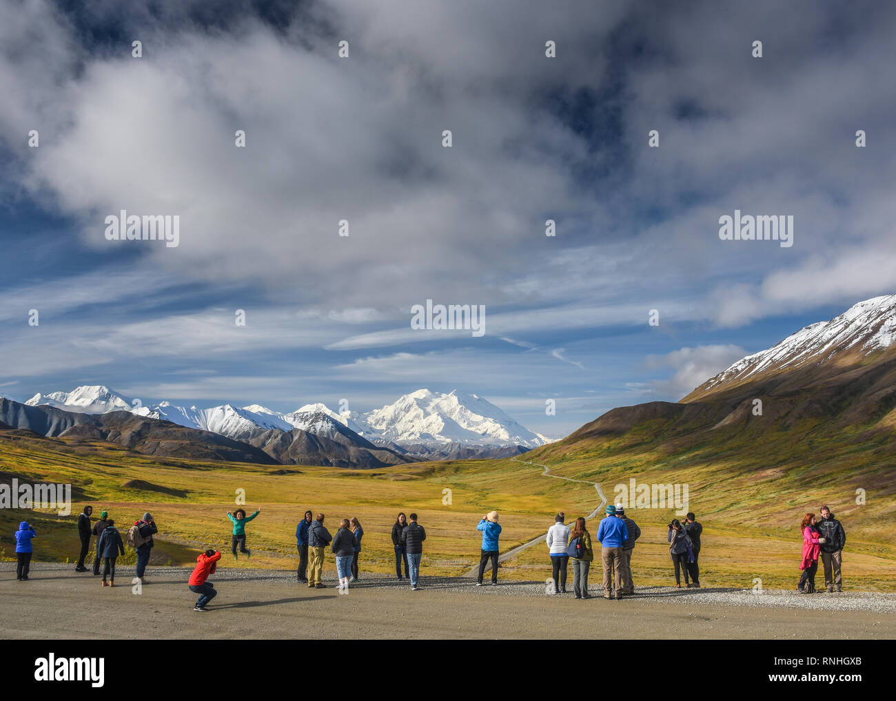 Tour bus Visitors admire the first view of Denali from the Park Road at Stony Pass, Denali National Park, Alaska, USA Stock Photo