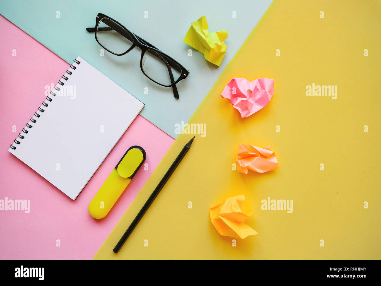 Blank notepad for text, glasses and other items on a multi-colored background. Stock Photo