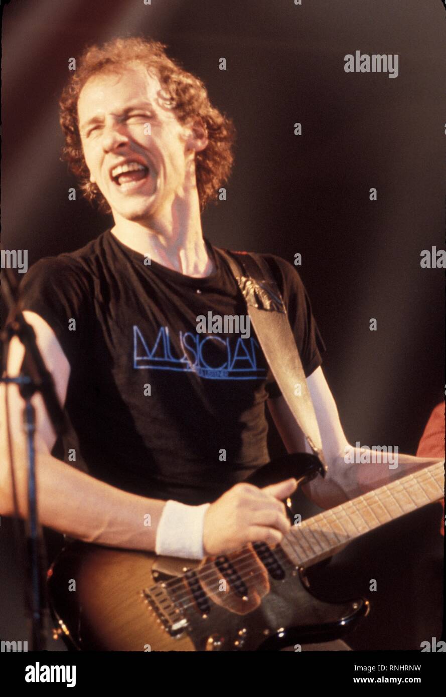 Mark Knopfler of Dire Straits is shown performing on stage during a concert  appearance Stock Photo - Alamy