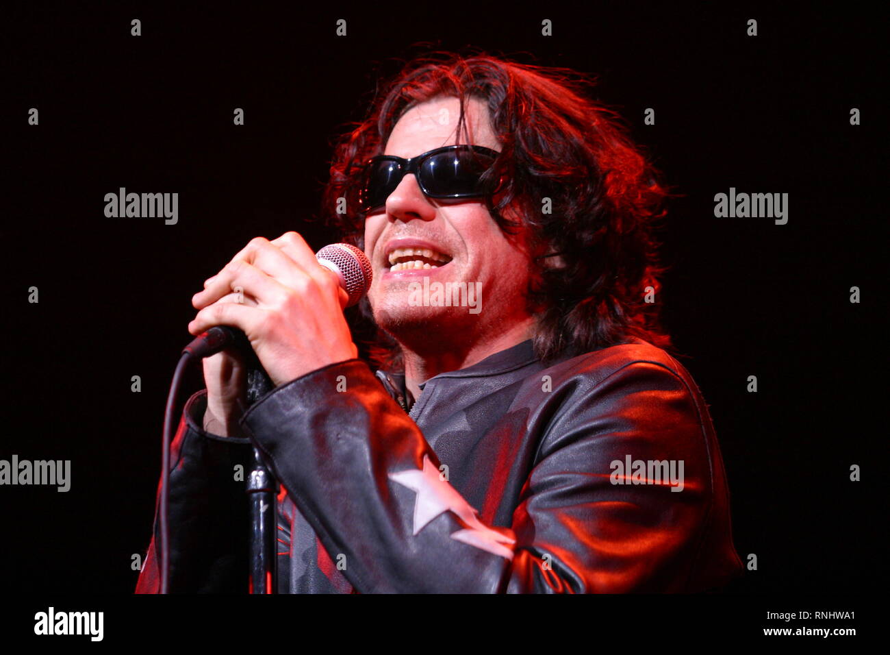 Singer Ian Astbury is shown performing on stage during a live concert appearance with The Doors. Stock Photo
