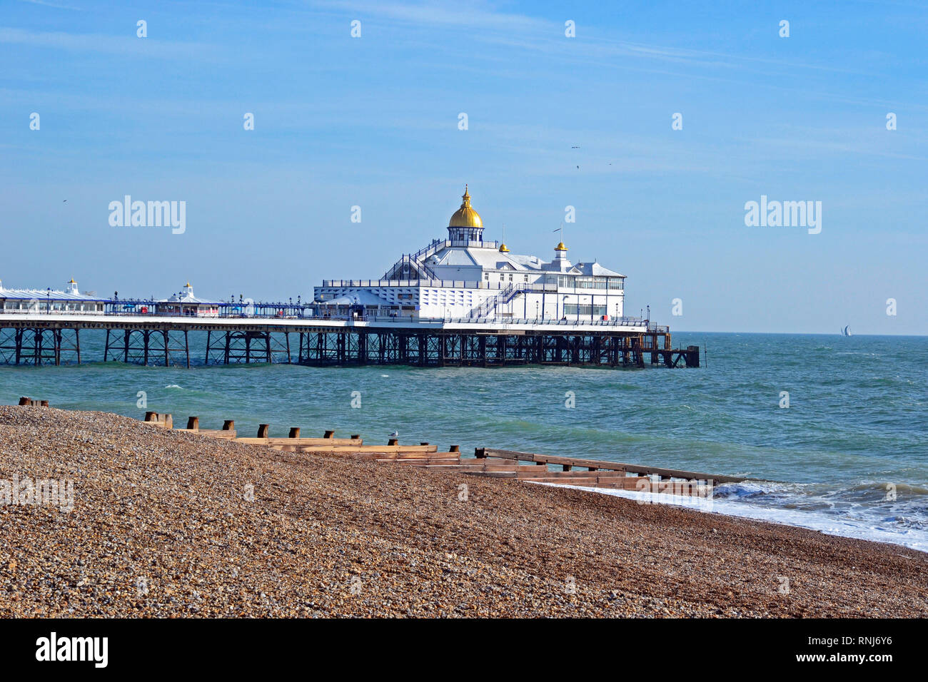 Eastbourne Pier, Eastbourne, East Sussex, UK. Brilliant sunshine brings people out to enjoy the seafront in February. View from the promenade. Stock Photo