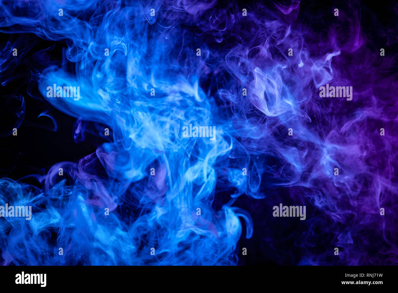 Blue and purple bomb smoke on black isolated background Stock Photo - Alamy