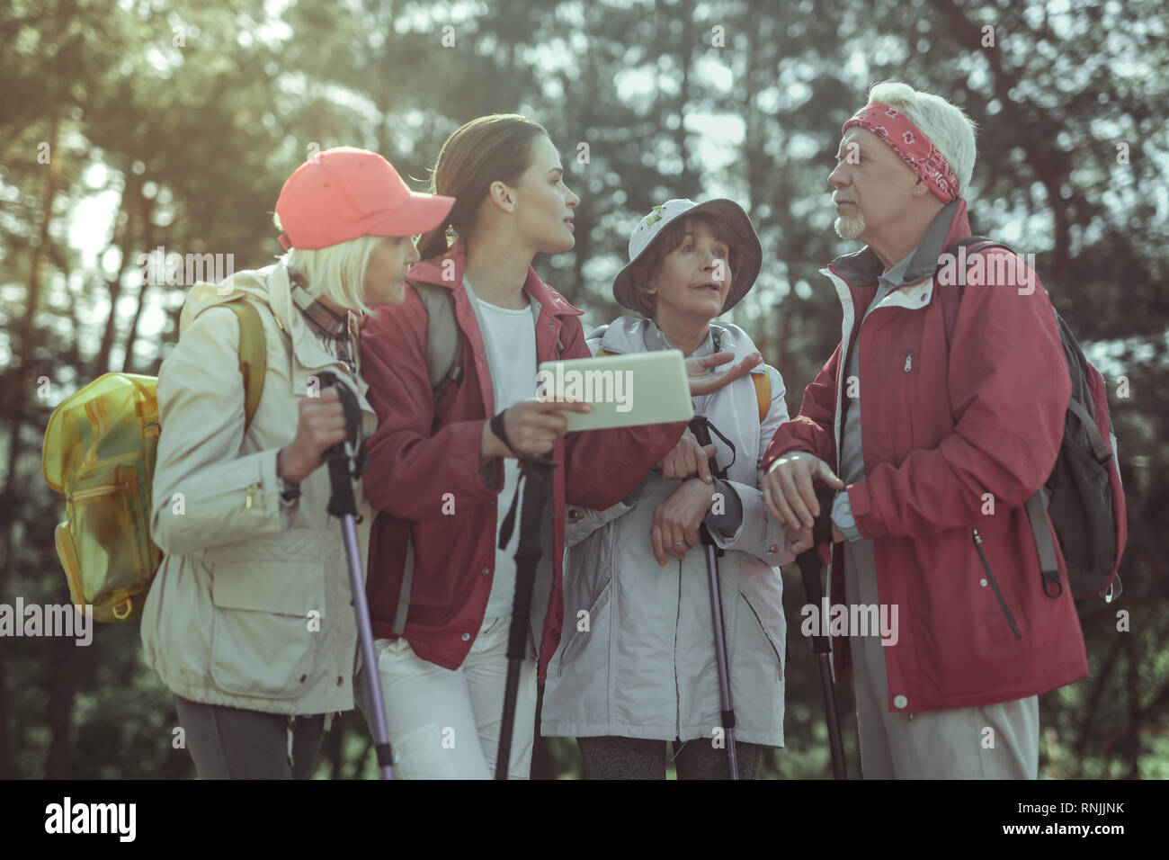 Tourists using GPS navigation on a tablet while hiking Stock Photo