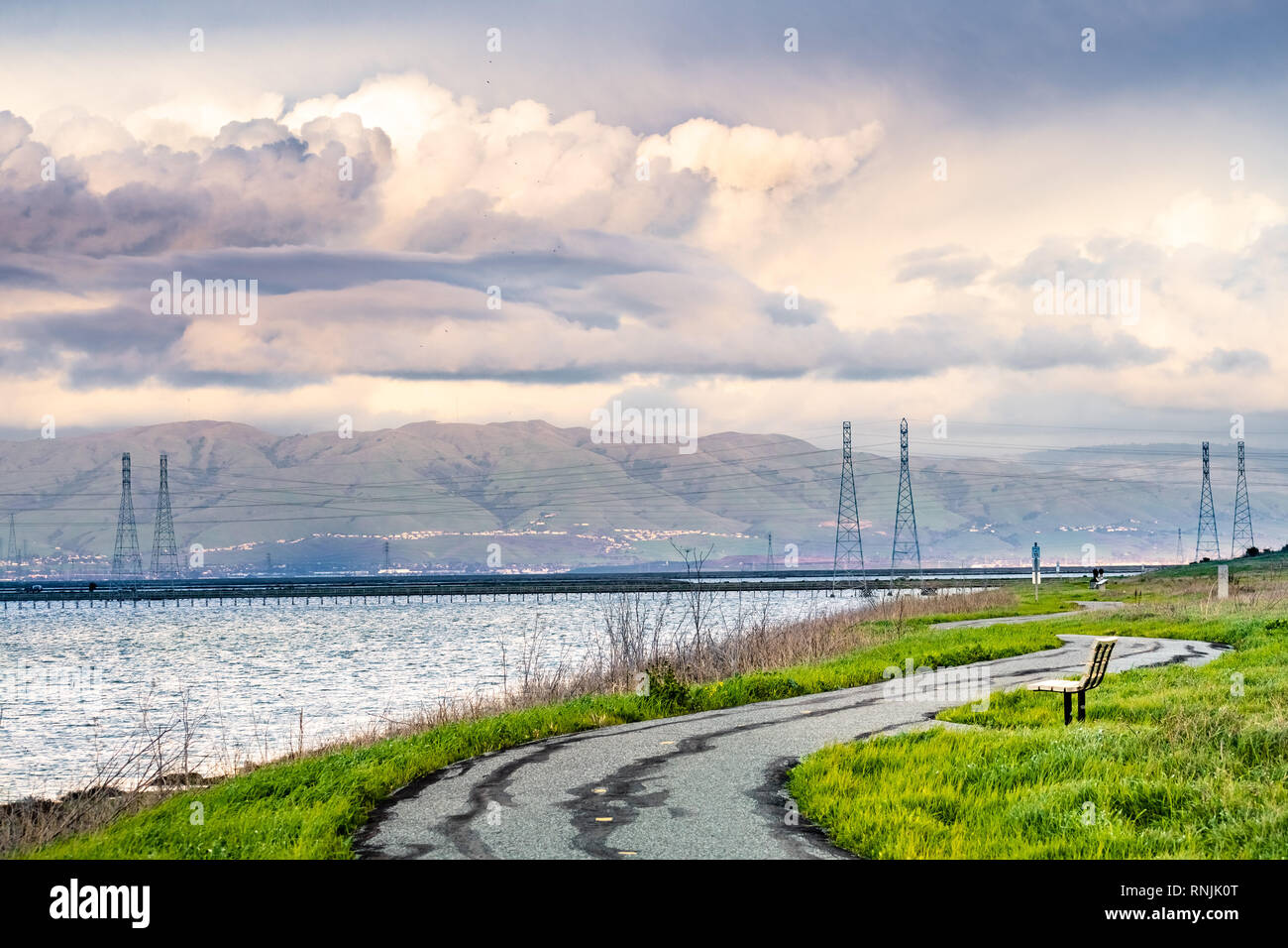 Paved trail following the green grass covered shoreline of south ...