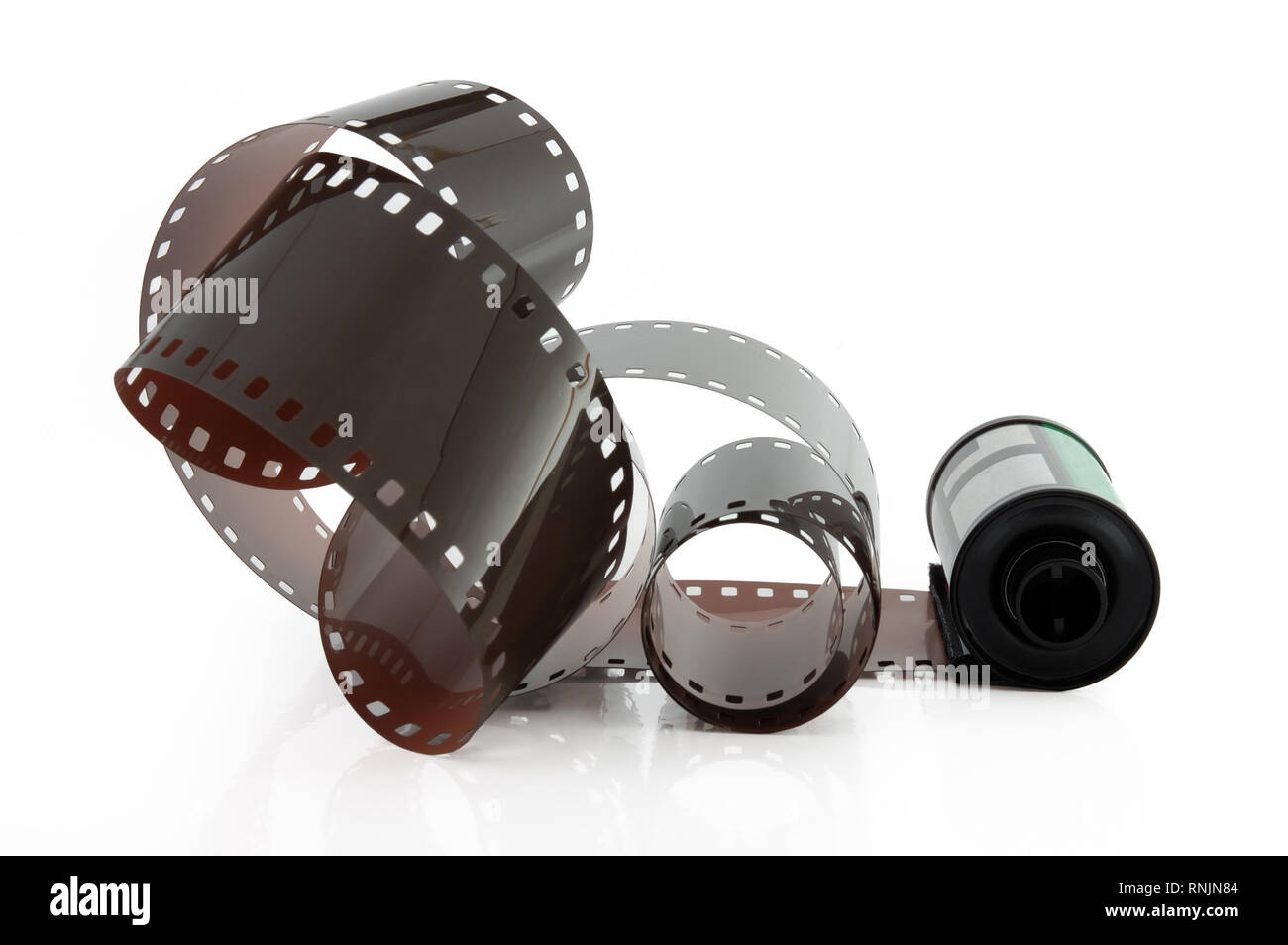 Old photographic 35 mm film with roll. Isolated on white background. Stock Photo