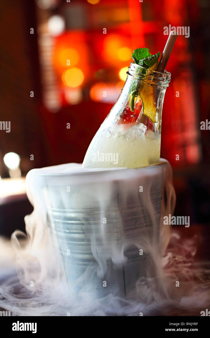 Mojito or lemonade serviced in the bottle with mint in the bucket with dry ice Stock Photo