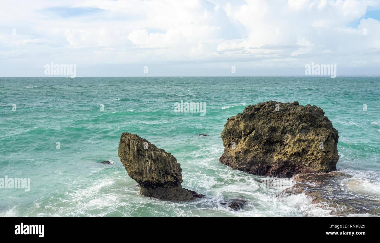 Two limestone rocks in the sea at The Rock Bar at Ayana Resort and Spa Jimbaran Bali Indonesia. Stock Photo