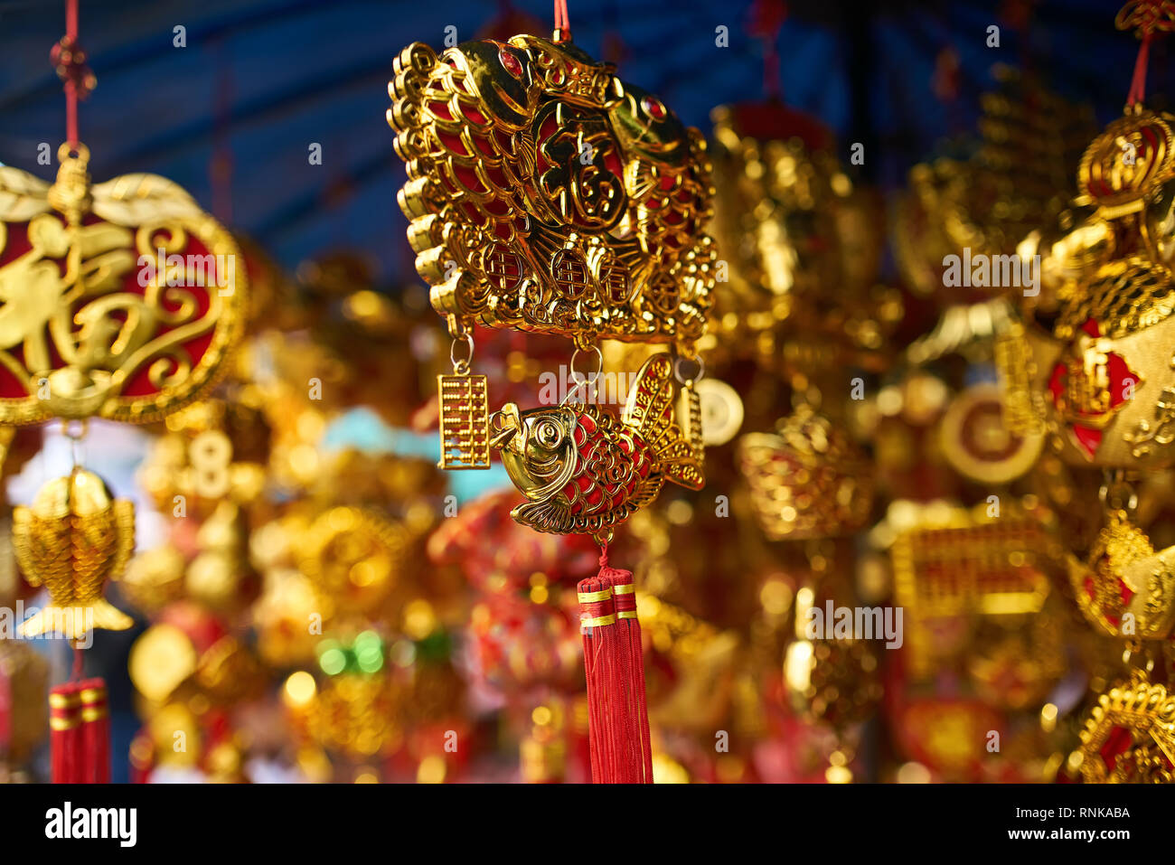 Traditional oriental golden-red decorations with fish figurines and ornaments on the street market during the celebration of Lunar New Year in Bangkok Stock Photo