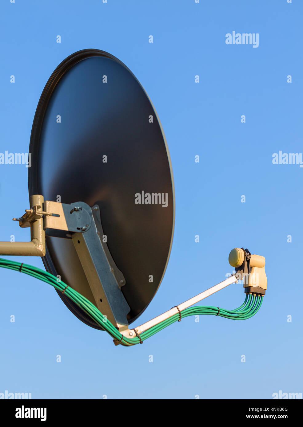 Residential TV receiver satellite dish with low-noise block downconverter (LNB). Satellite dish antenna with octo monoblock converter over blue sky. Stock Photo