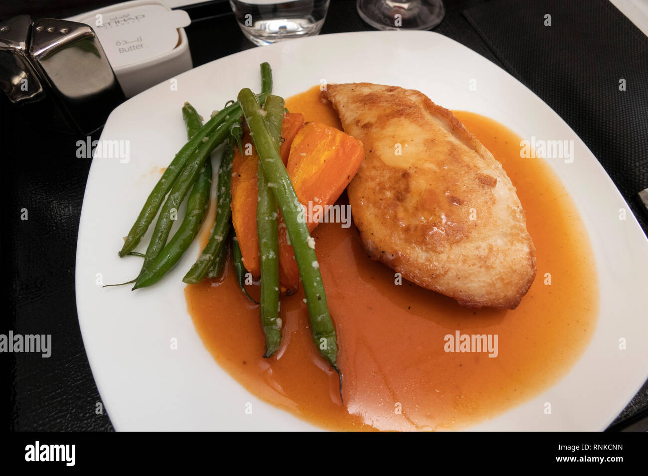 Air Travel, Etihad Airways Boeing 777-300, Business Class in flight meal,, low carbohydrate lunch, grilled chicken with carrot and green beans Stock Photo
