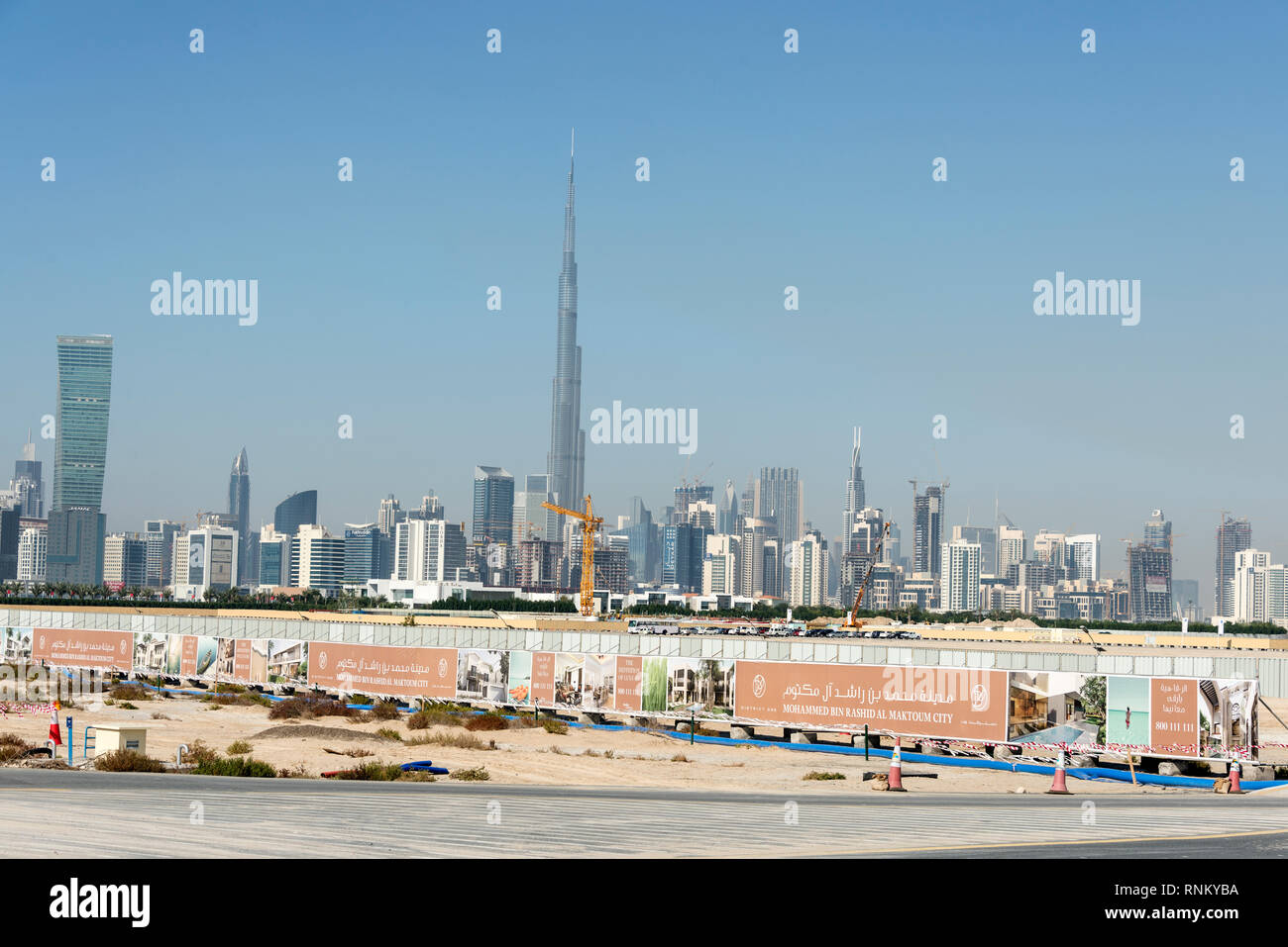 Skyline of downtown Dubai including the tall kilometre high metal structure of the Burj Khalifa, known as the Burj Dubai near the Dubai Race Course in Stock Photo