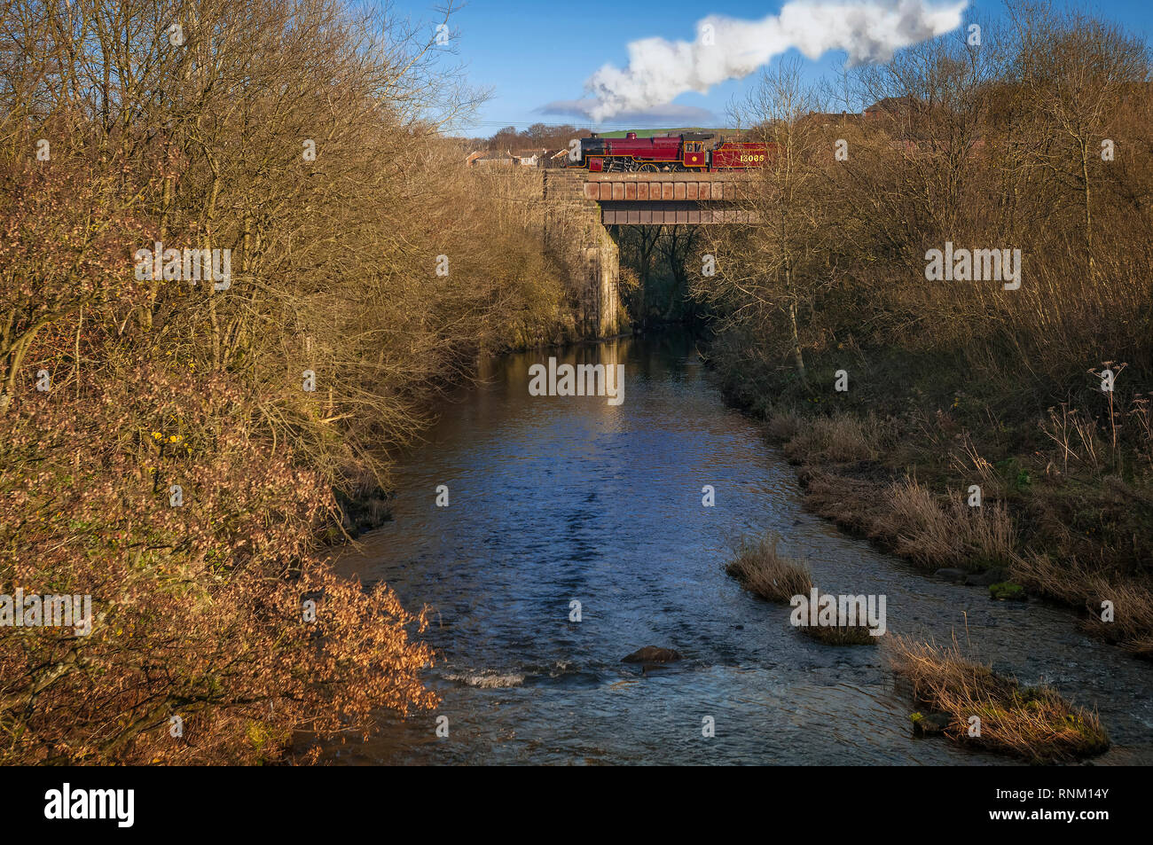 The ' Crab ' Mogul locomotive passing over the River Irwell at Burrs Country Park on the East Lancashire heritage railway at Bury in Lancashire. Stock Photo