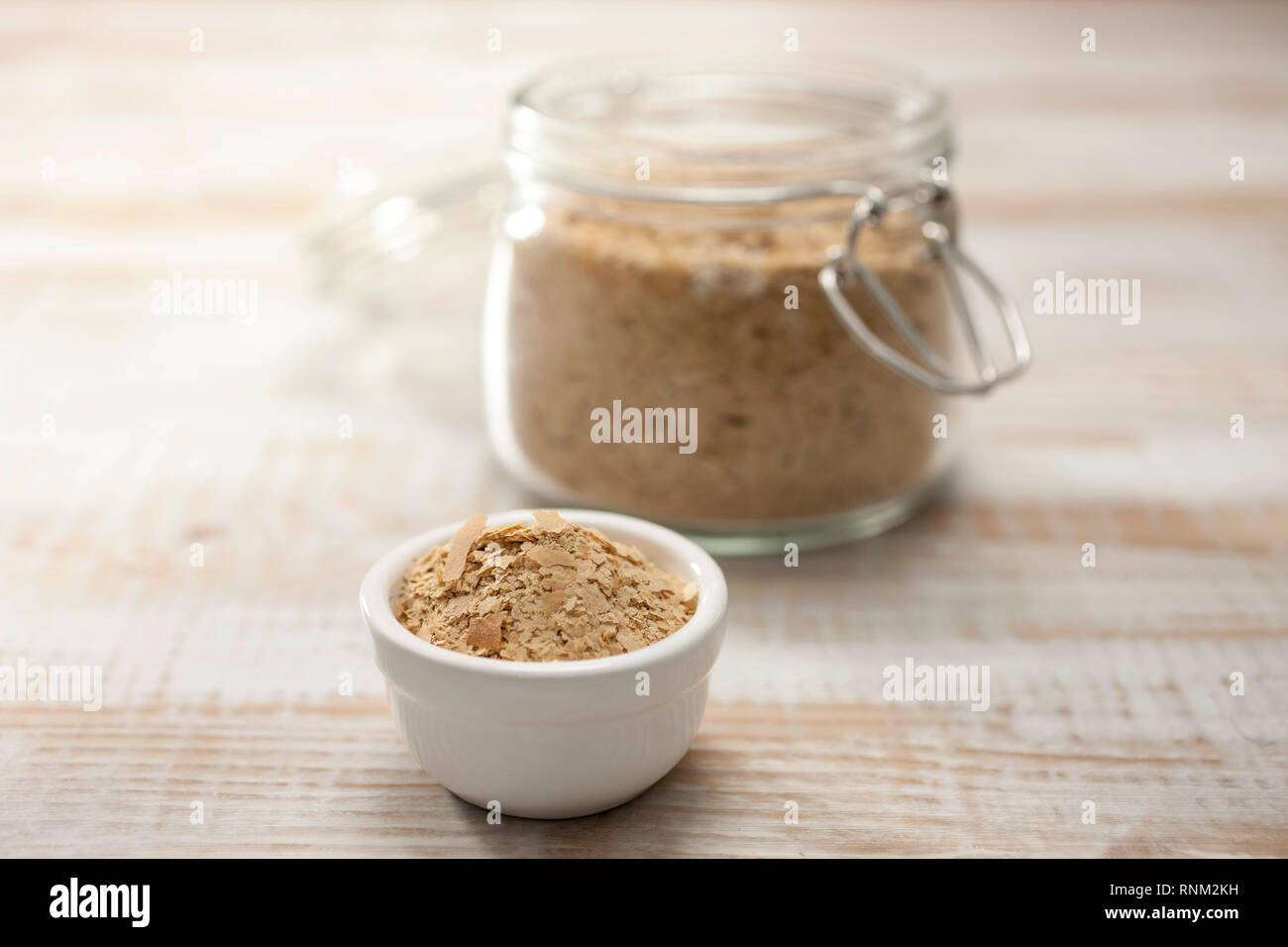 Nutritional yeast flakes in a dish on parque. Stock Photo