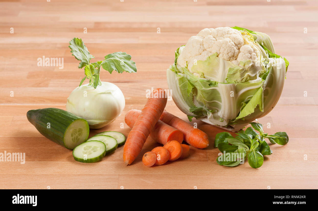 Vegetables and herbs: Basil, cauliflower, cucumber, carrot and Kohlrabi, German Turnip. Studio picture on parquet. Stock Photo