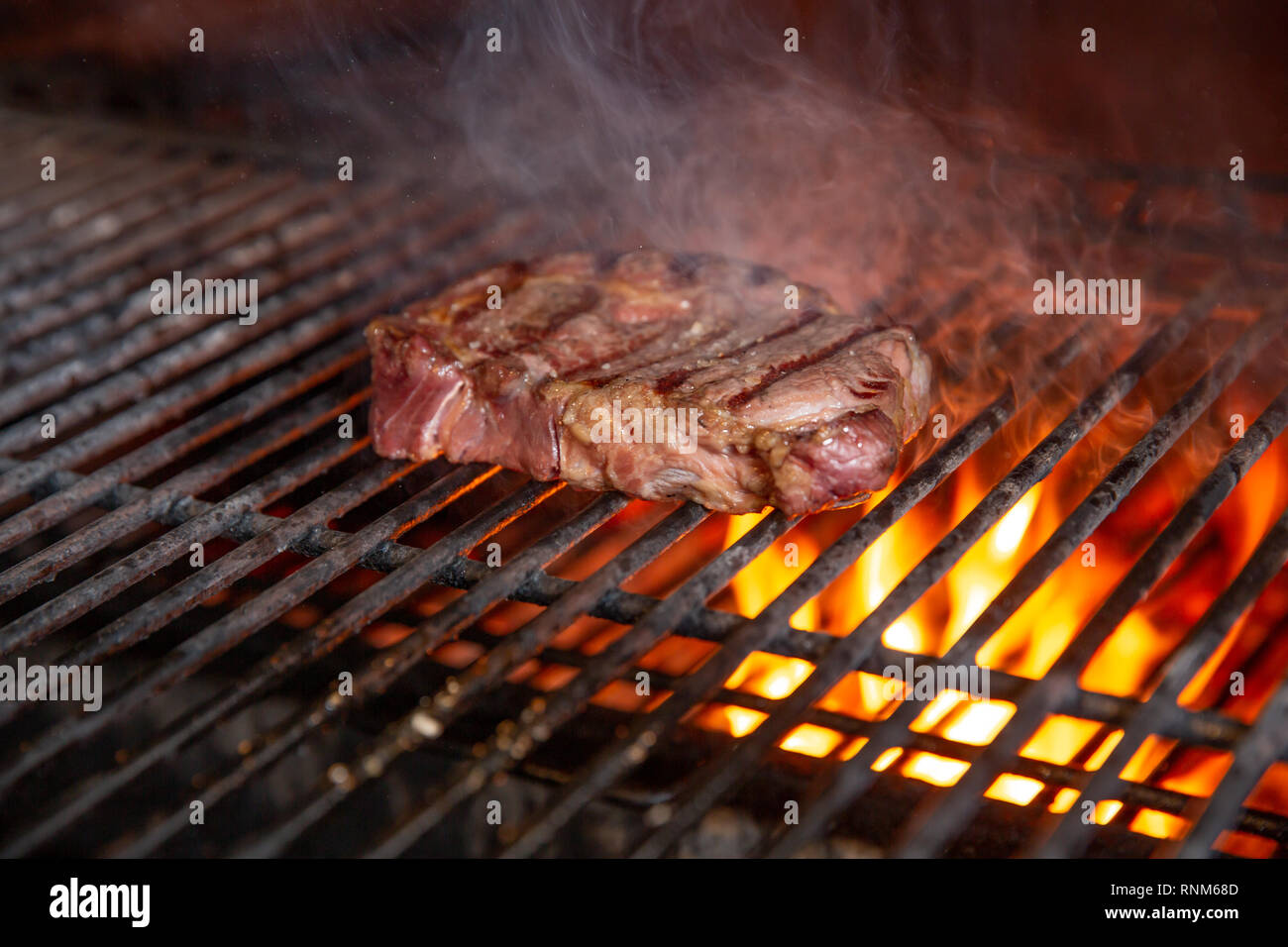A top sirloin meat steak flame broiled on a barbecue, shallow depth of