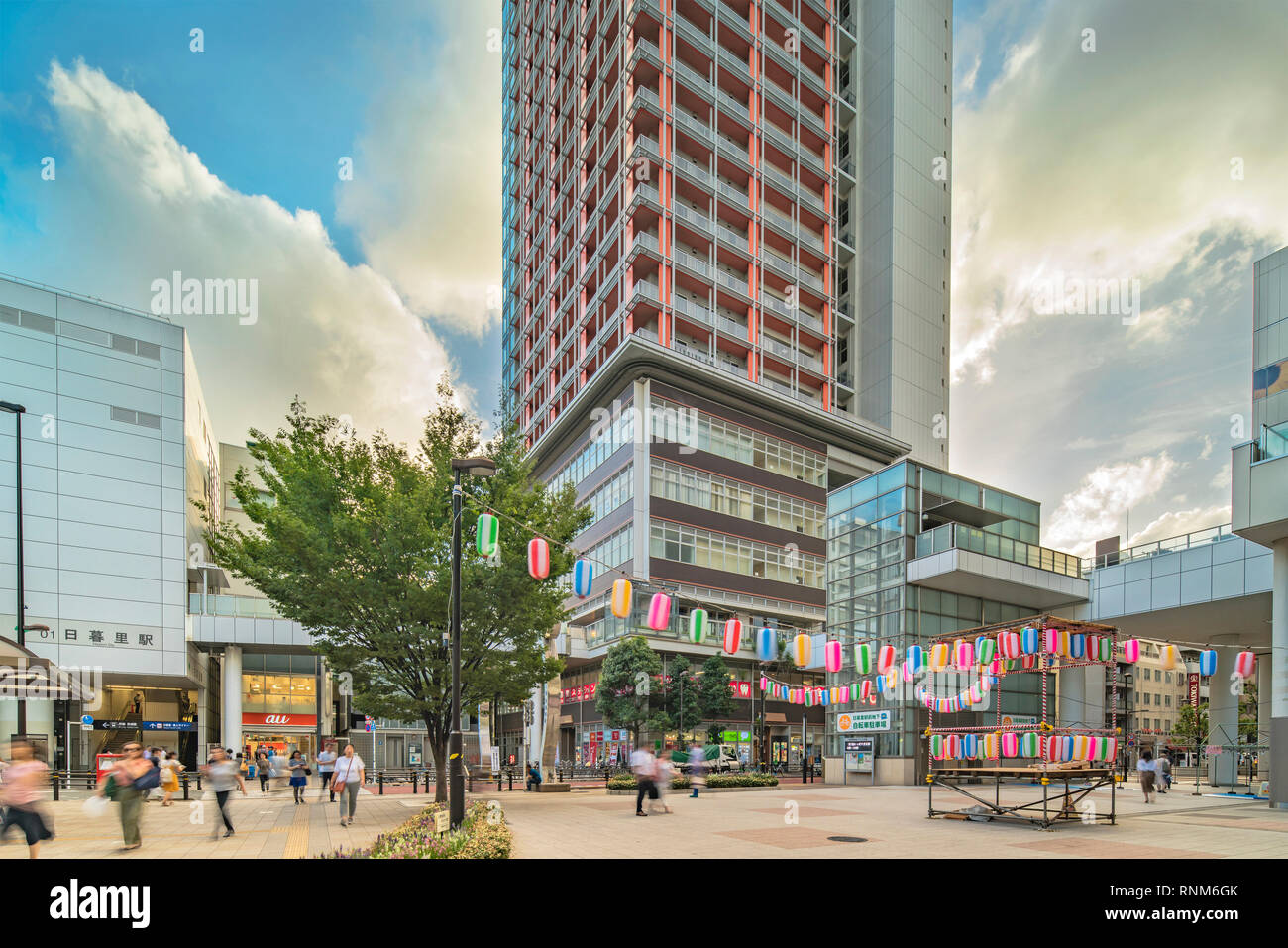 View of the square in front of the Nippori train station decorated for the Obon festival in the sunset summer sky with a yagura tower and paper lanter Stock Photo