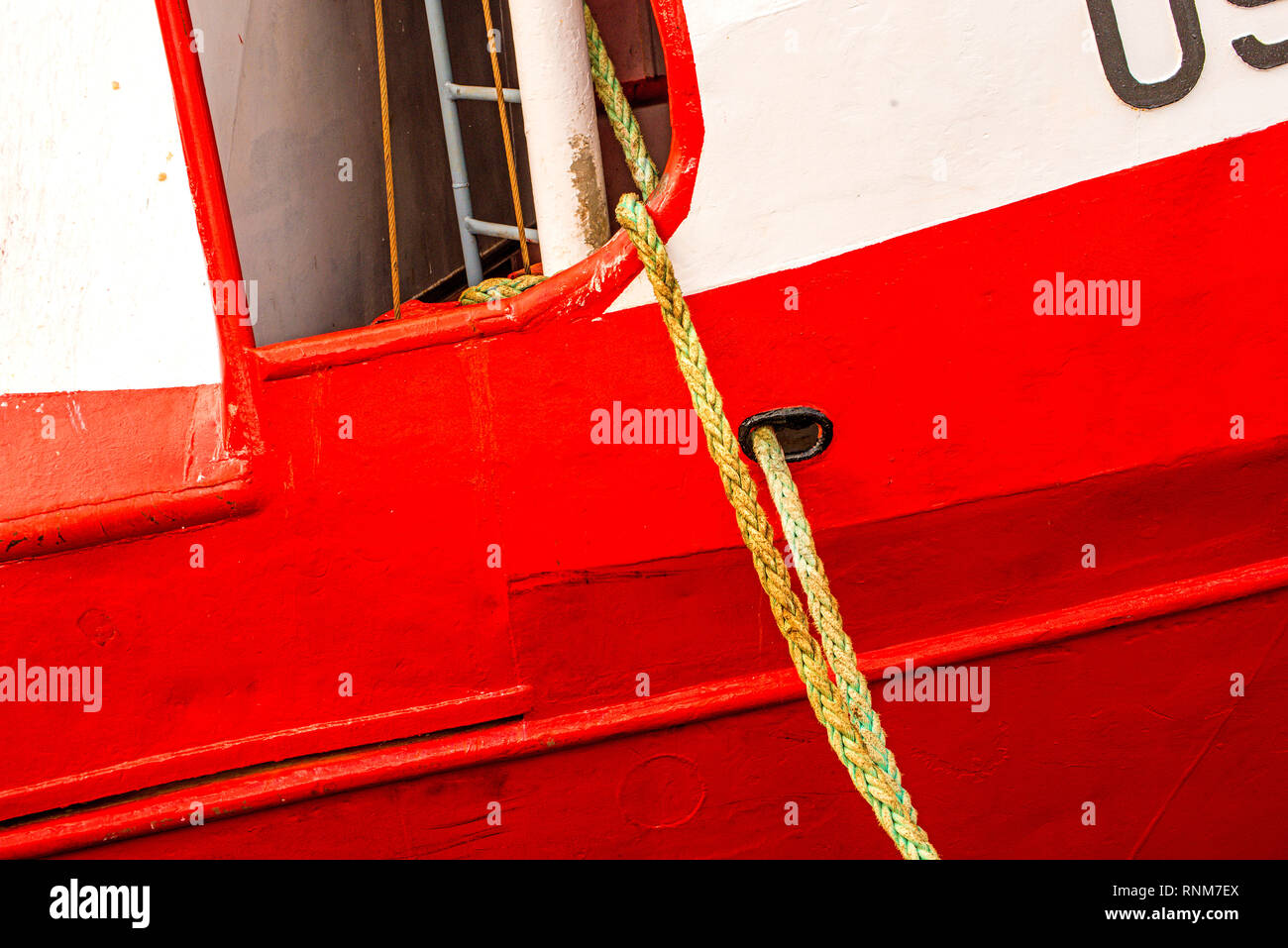 Mooring line of a trawler on a red ship hull Stock Photo Alamy