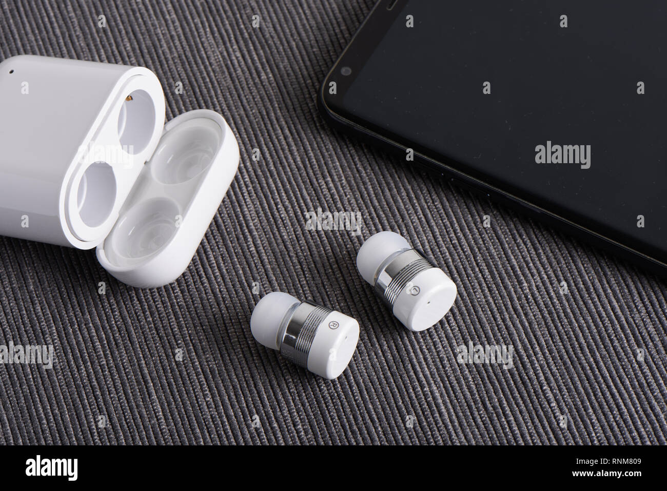 wireless cordless bluetooth earbuds with chargeable case and smartphone Stock Photo