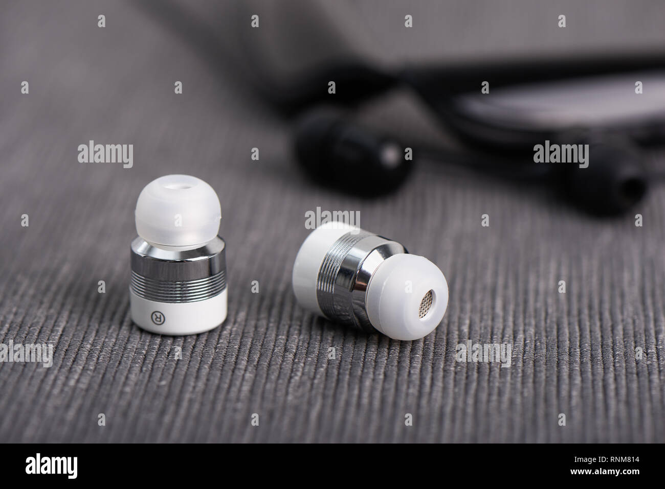 wireless cordless bluetooth earbuds on a background of neck band type earphone Stock Photo