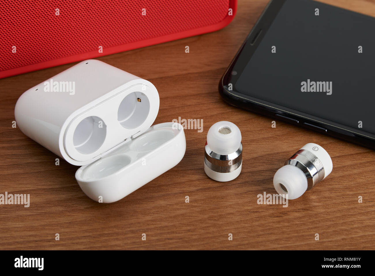 wireless cordless bluetooth earbuds and chargeable case with smartphone and partable speaker Stock Photo