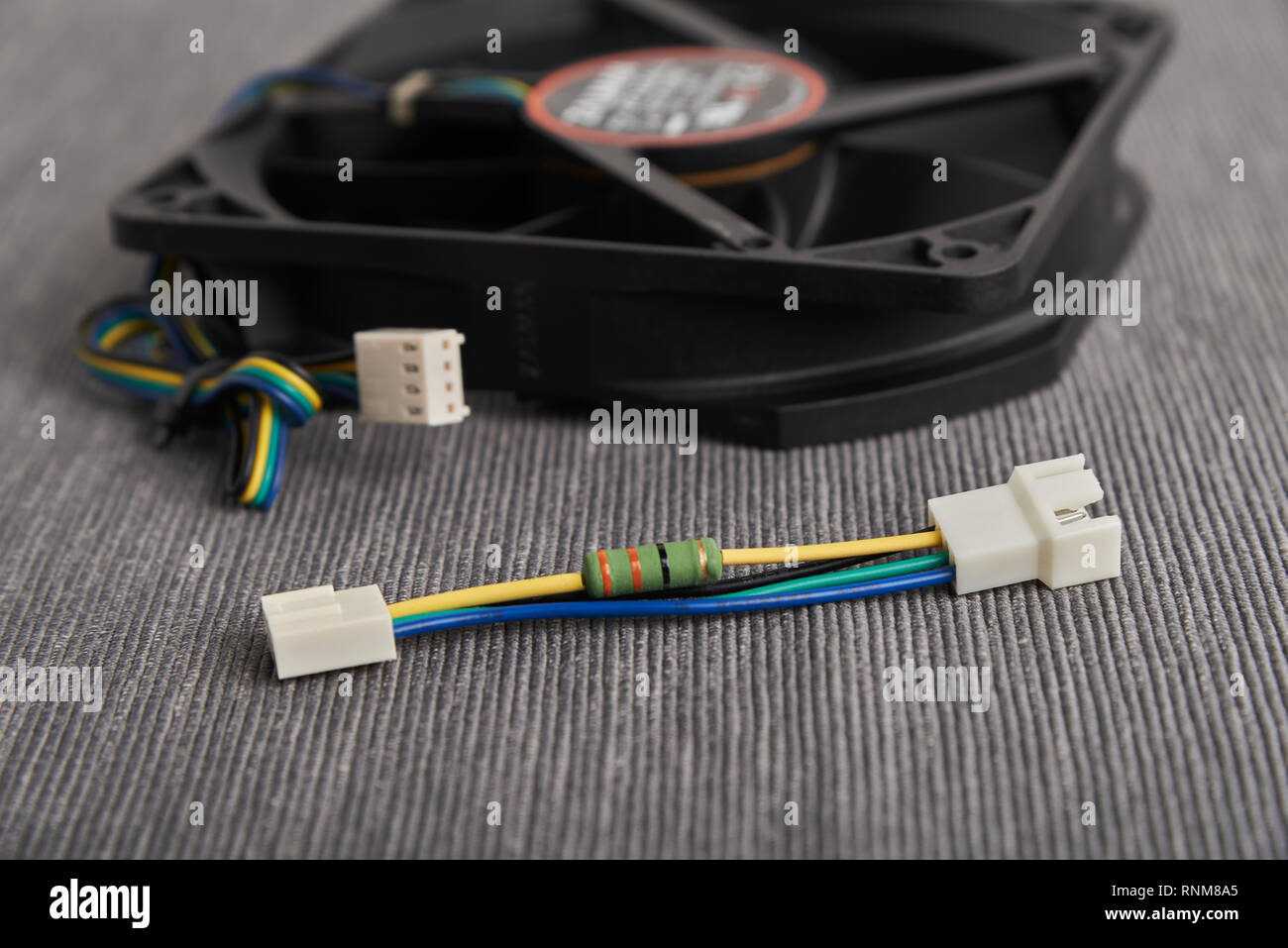 Computer fan and noise resistor cable to reduce computer fan speed