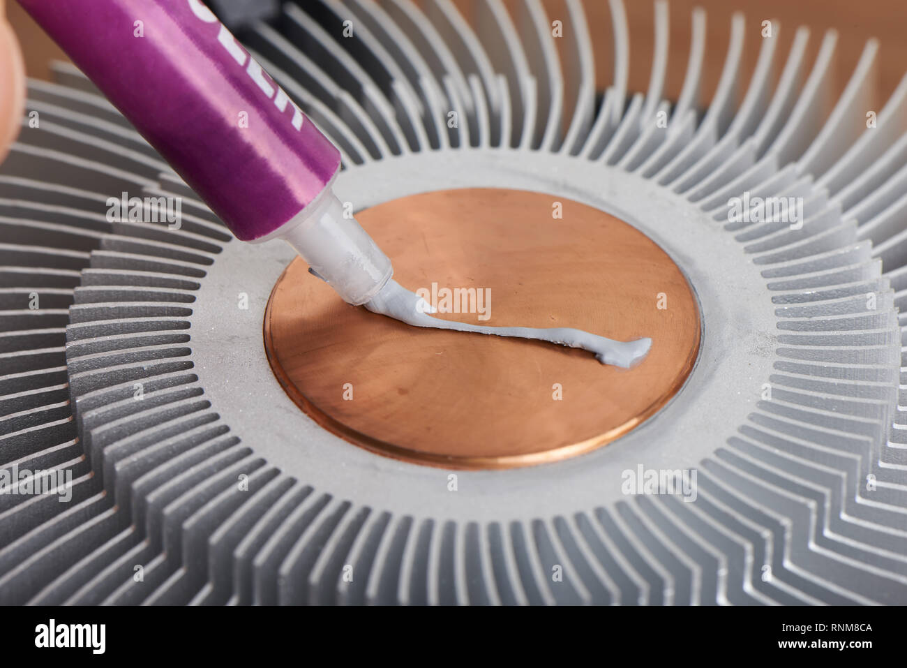 applying thermal paste to the surface of heat sink Stock Photo