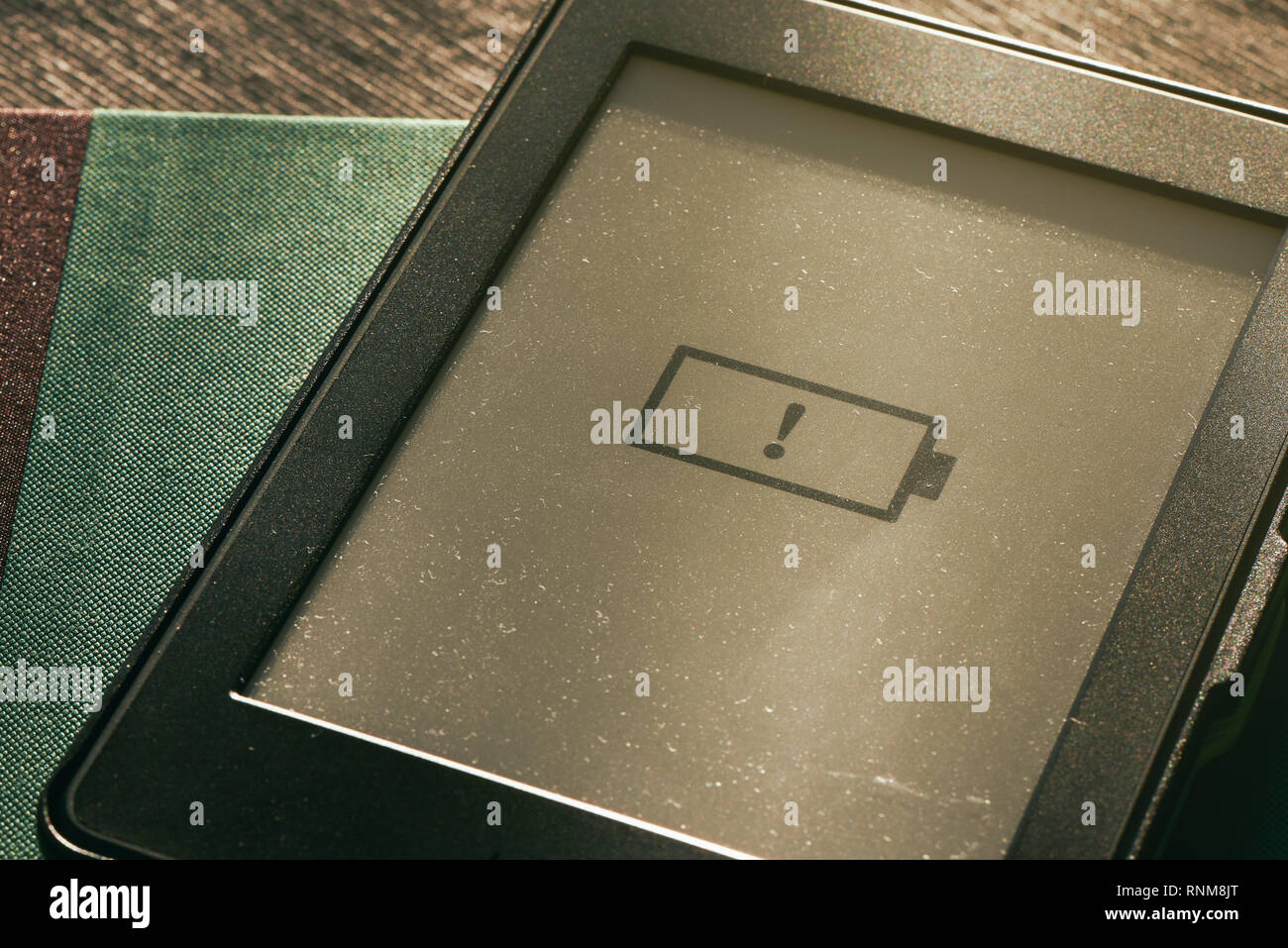 low battery icon on e-book e-reader screen with warm sunlight Stock Photo