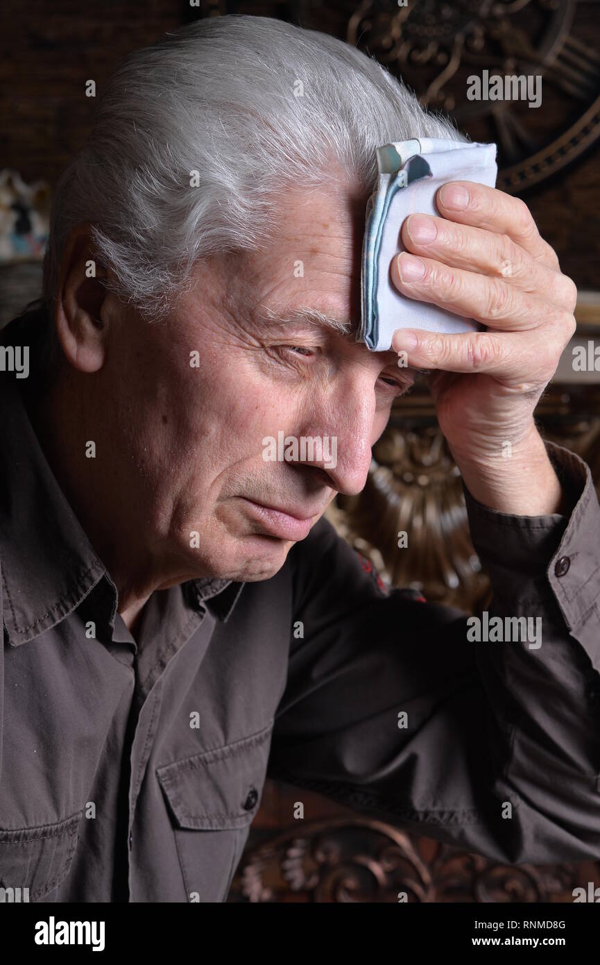 Portrait of sick senior man with handkerchief Stock Photo