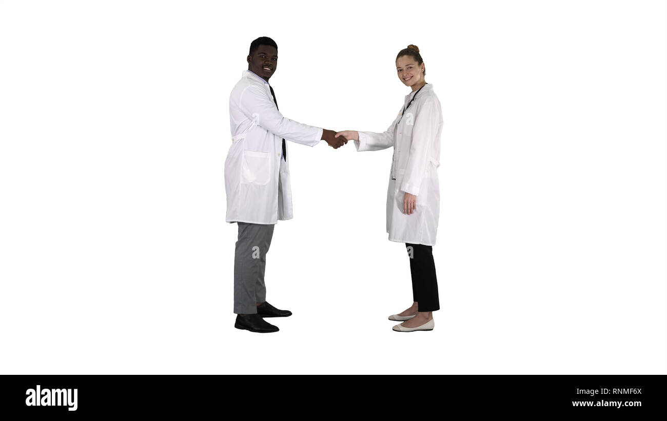 Doctors shaking hands and posing to camera on white background. Stock Photo