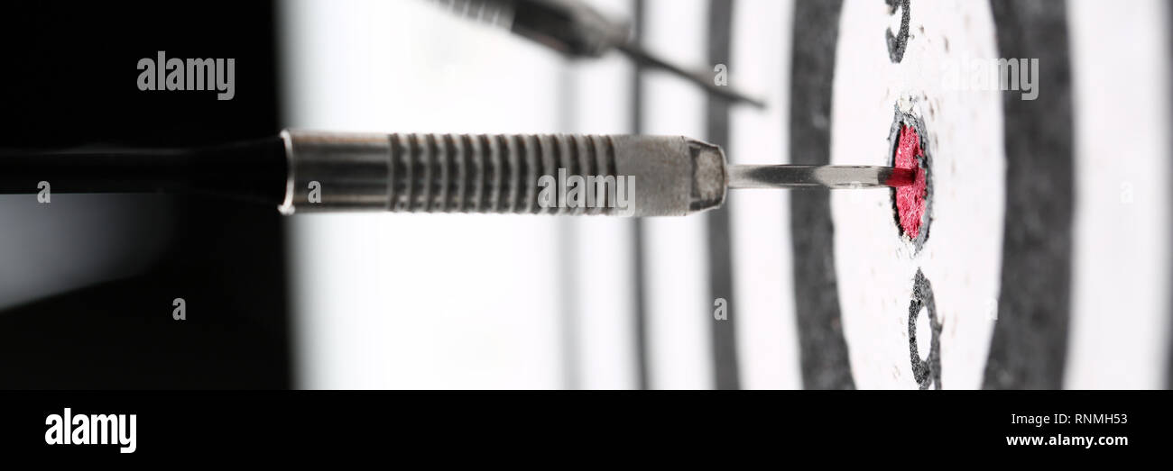The dart game sticks out in the center of the red Stock Photo