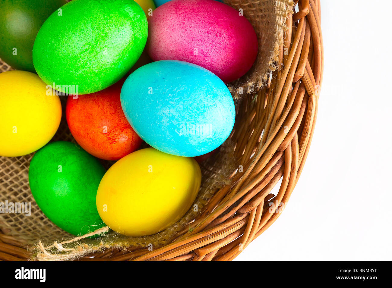 Brightly colored closeup easter eggs in basket, holiday background Stock Photo