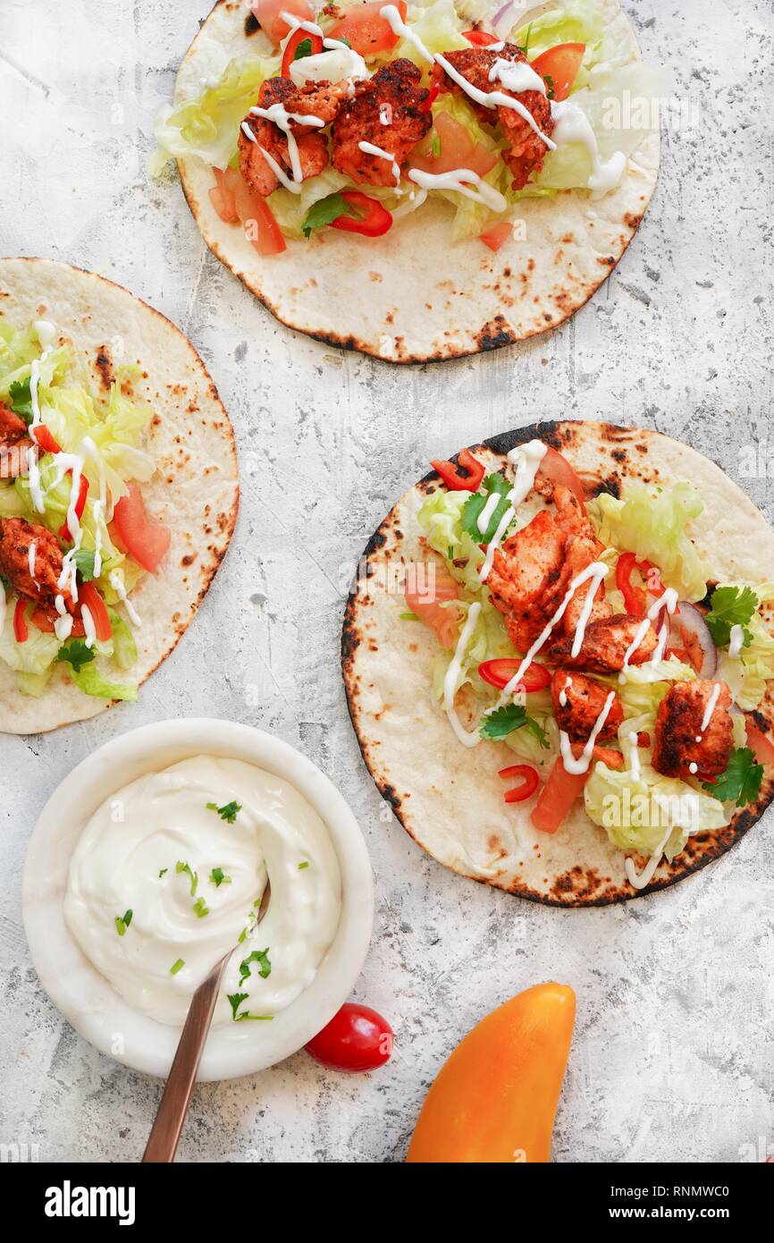 Homemade soft Grilled salmon fish Tacos drizzled with sour cream, selective focus Stock Photo