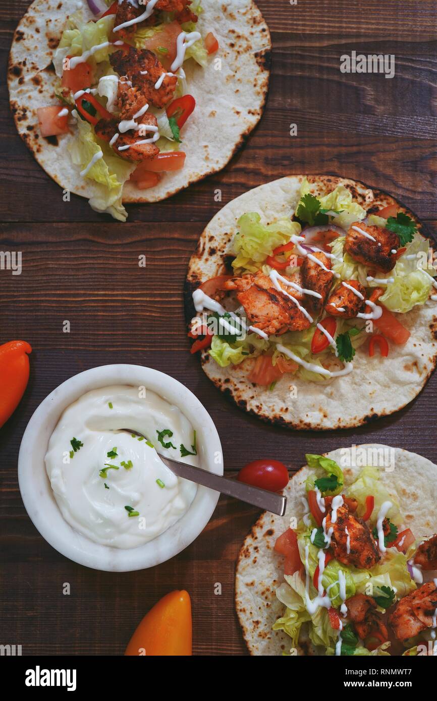 Homemade Chicken Tikka soft  Tacos drizzled with sour cream, overhead view Stock Photo