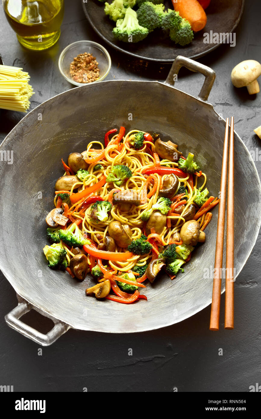 Vegan vegetarian stir-fry noodles with vegetables in wok pan on black stone  background. Top view, flat lay Stock Photo - Alamy