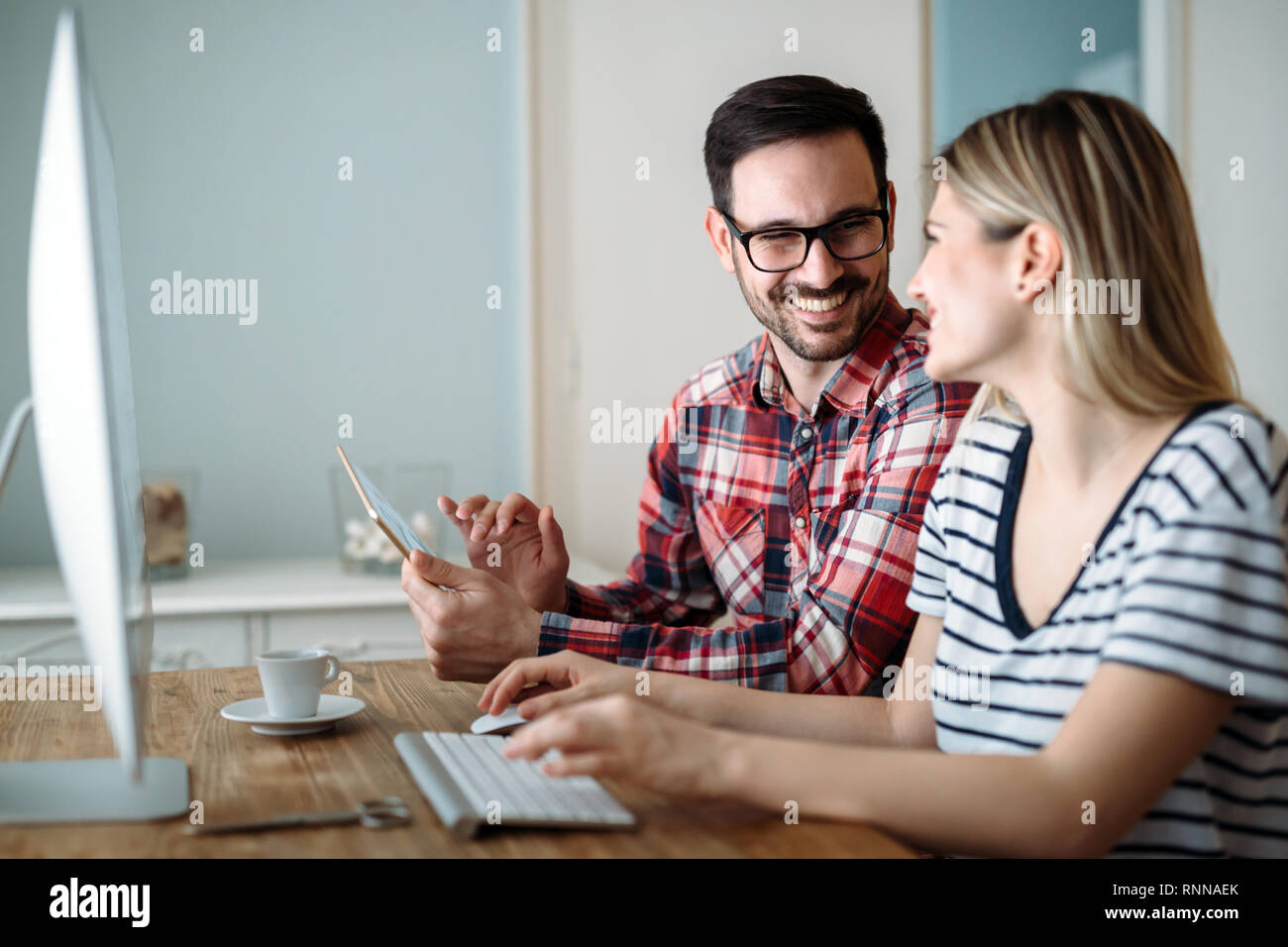 Young attractive designers working on project together Stock Photo - Alamy