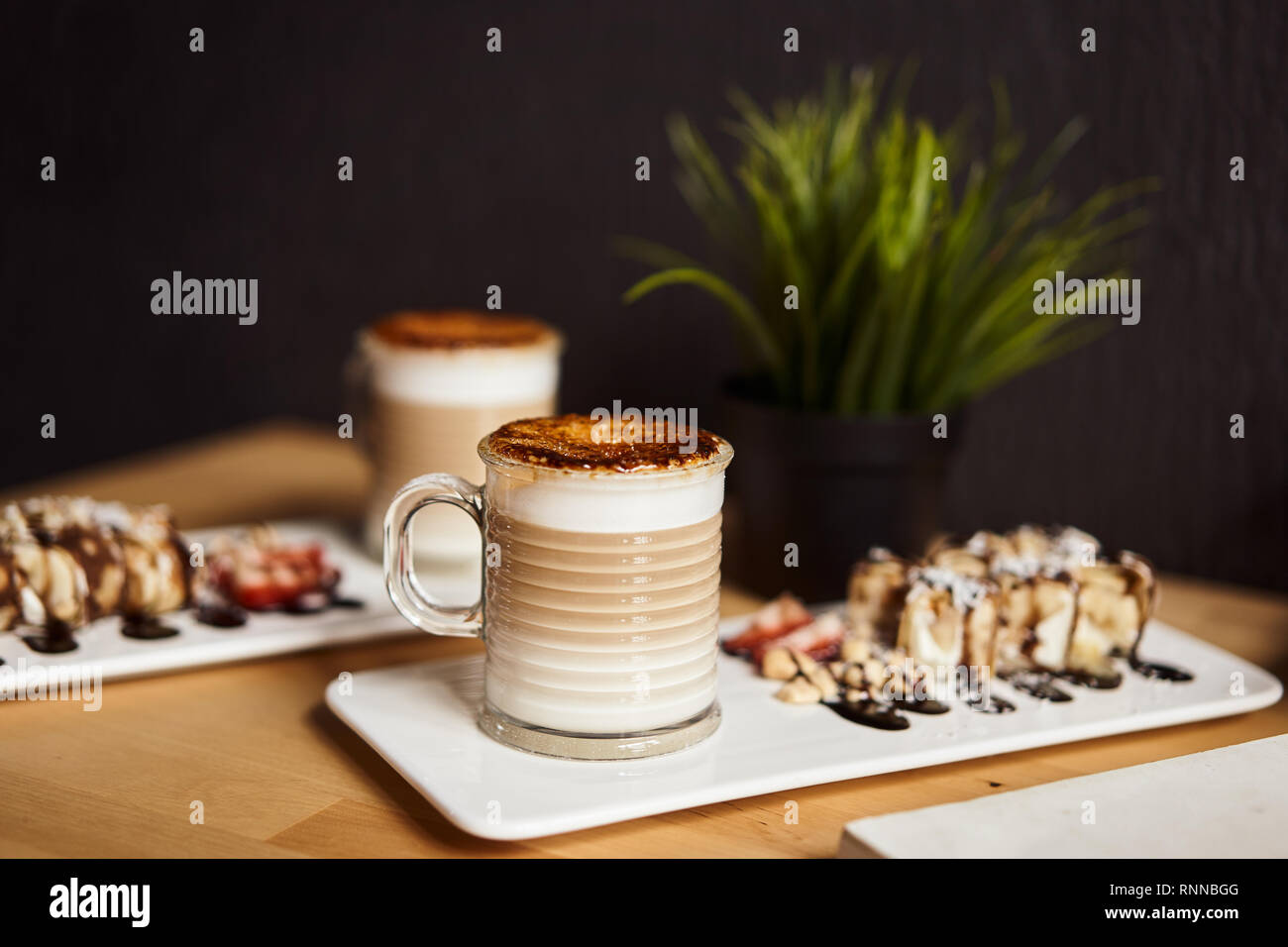 Two Cups Of Hot Latte With Baked Caramel Crust And Sweet Roll With Banana And Strawberry On The Wooden Table In Coffe Shop Coffee Concept Stock Photo Alamy