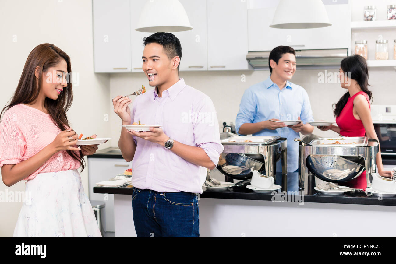 Couple enjoying the food at a house party Stock Photo