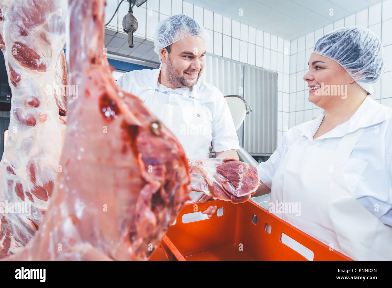 Team of butchers working with meat in butchery Stock Photo